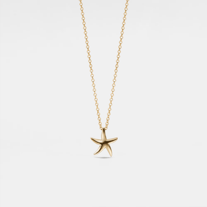 Gold starfish pendant necklace on a light gray background