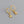 A pair of hoop earrings with starfish charms attached, plated in gold, displayed against a grey background.