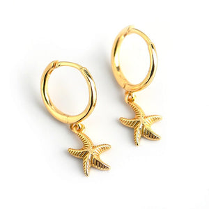 A pair of hoop earrings with starfish charms attached, plated in gold, displayed against a white background.