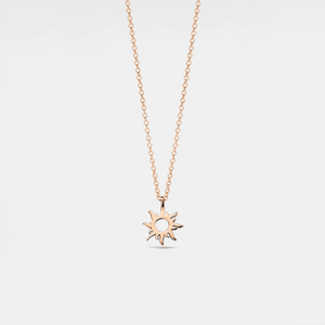 A rose gold-plated sterling silver necklace with a sun charm pendant on a chain.