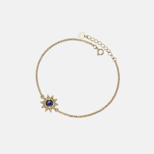 Gold bracelet with a star-shaped pendant on a light gray background