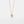 Gold necklace with a sun-shaped pendant on a light gray background