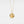 Gold necklace with a round locket feature a sun face design on a light gray background