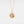 Rose gold necklace with a round locket feature a sun face design on a light gray background