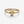 A gold-colored ring featuring a sun motif with rays extending outward, set with small cubic zirconia stones.