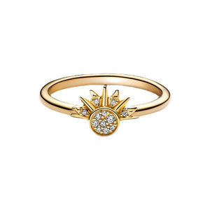 A gold-colored ring featuring a sun motif with rays extending outward, set with small cubic zirconia stones.
