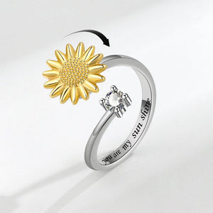 Ring with gold sunflower and silver heart with 'You are my sunshine' engraving on a light gray background
