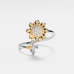 Gold and silver sunflower-shaped ring with diamond accents on a light gray background