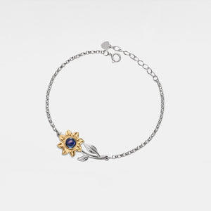 Silver bracelet with gold sunflower design featuring a projection gemstone on a white background