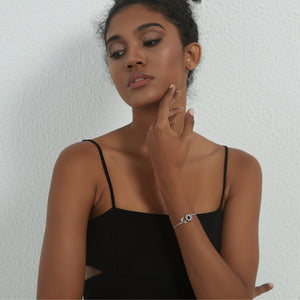 A model wearing a silver bracelet with silver sunflower design featuring a projection gemstone on a white background