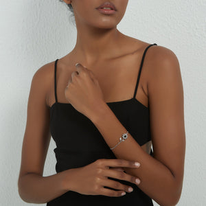 A model wearing a silver bracelet with silver sunflower design featuring a projection gemstone on a white background