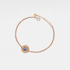 Rose gold bracelet with a sunflower-shaped charm and projection gemstone on a light gray background
