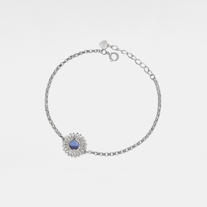 Silver bracelet with a sunflower-shaped charm and projection gemstone on a light gray background