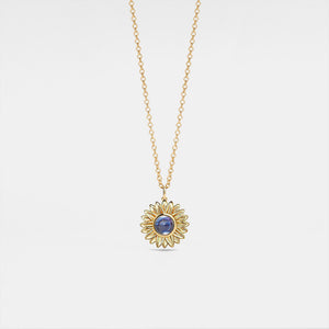 A gold-plated sterling silver necklace with a sunflower charm and a central projection stone, displayed on a white background.