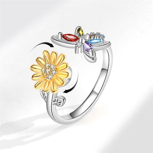 Silver ring with a gold sunflower and colorful gemstones on a white background