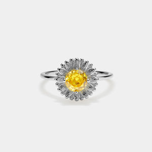 Silver ring with a yellow gemstone on a white background