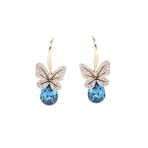 Butterfly earrings with blue gemstones on a white background