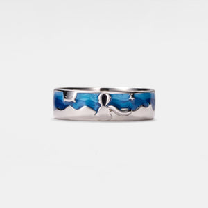 A silver band ring with blue enamel design featuring the lttle prince and a star