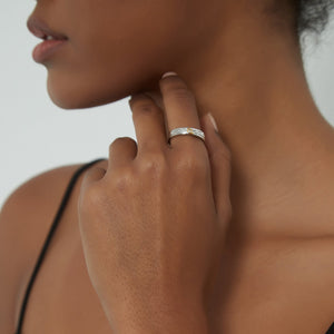 Woman wearing a silver ring with gold little prince sitting on the moon on a white background