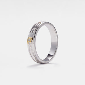 Silver ring with gold little prince sitting on the moon on a white background