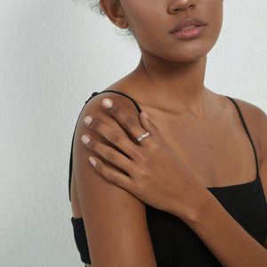 Woman wearing a silver ring with gold little prince sitting on the moon on a white background