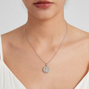 Sterling silver round locket necklace with a “Little Prince” engraved design and star detail, worn on a delicate chain on a model’s neck.