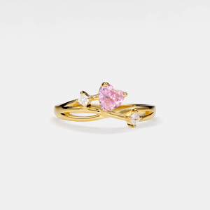 Gold vine ring with a pink heart-shaped gemstone on a white background