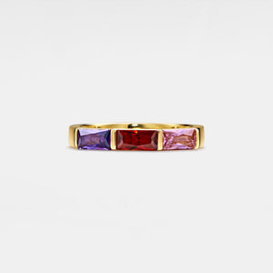 Gold ring with three colorful gemstones on a white background