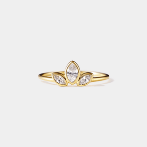 Gold ring with three diamond stones on a light gray background