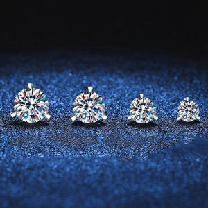 Four diamond stud earrings on a dark blue textured background