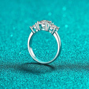 Silver ring with three diamonds on a teal glittery background