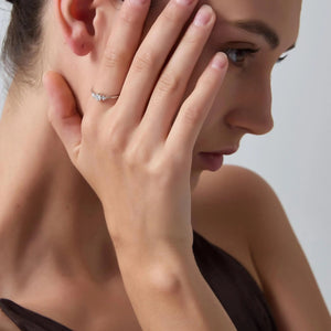 Woman with hand on face against a neutral background