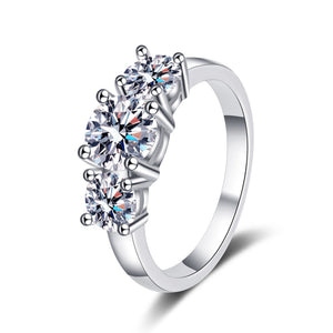 Silver ring with three clear gemstones on a white background