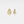 Gold hoop earrings with small diamonds on a light gray background