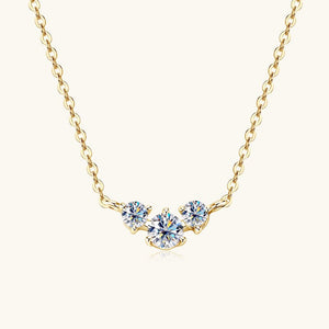 Gold necklace with three diamond-like stones on a white background