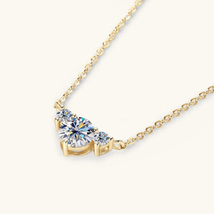 Gold necklace with a large diamond pendant on a white background