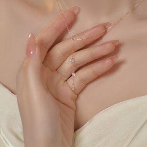 Delicate gold chain with pink gemstones worn by a person