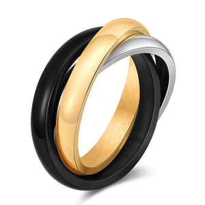 Three ring stack featuring gold, black, and silver bands on a white background