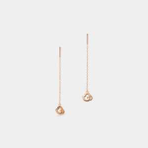 Rose gold heart-shaped earrings on a light gray background