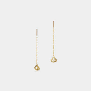 Gold heart-shaped earrings on a light gray background
