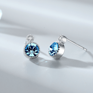 Silver earrings with blue gemstones on a light gray background
