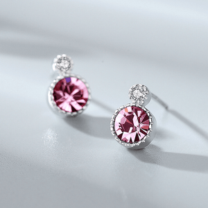 Pair of earrings with pink gemstones on a light gray background