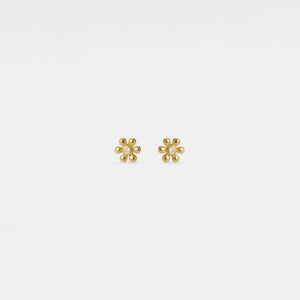 Gold flower-shaped earrings with clear gemstones on a white background