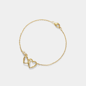 Gold bracelet with heart-shaped links on a light gray background