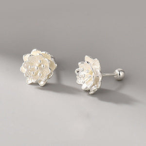Pair of silver floral earrings on a gray background