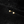Pair of gold earrings with pearl-like stones on a black textured background