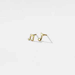 Gold music note earrings on a light gray background