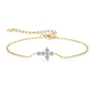 A sterling silver bracelet with a small cross charm adorned with moissanite stones, displayed against a white background.