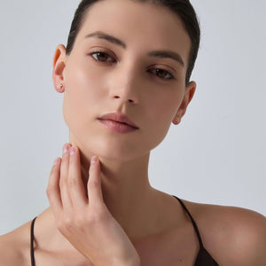 Woman touching her neck with a plain background