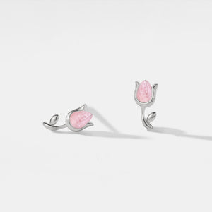 Pair of silver earrings with pink gemstones on a light gray background